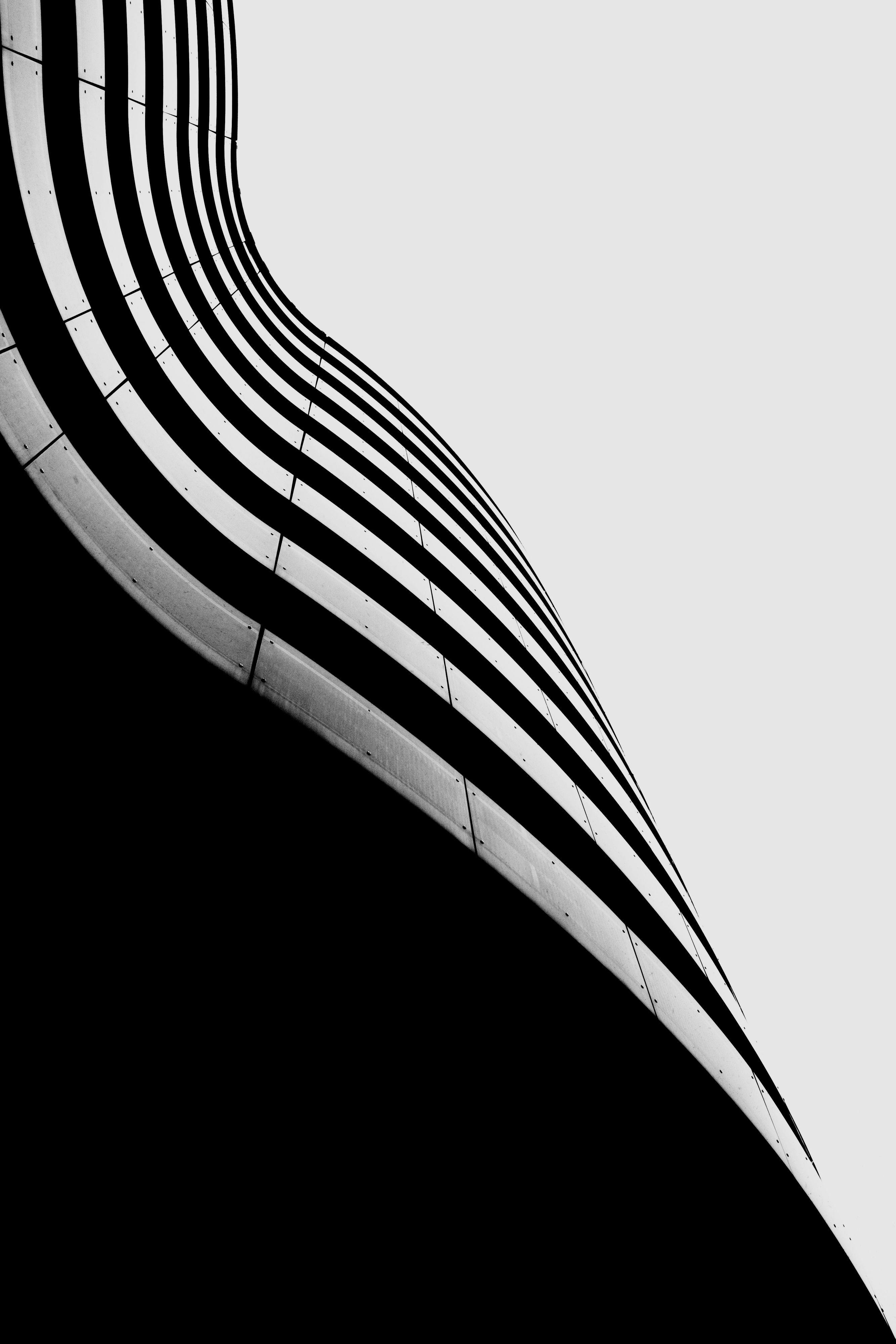 A curved building surface with sky
